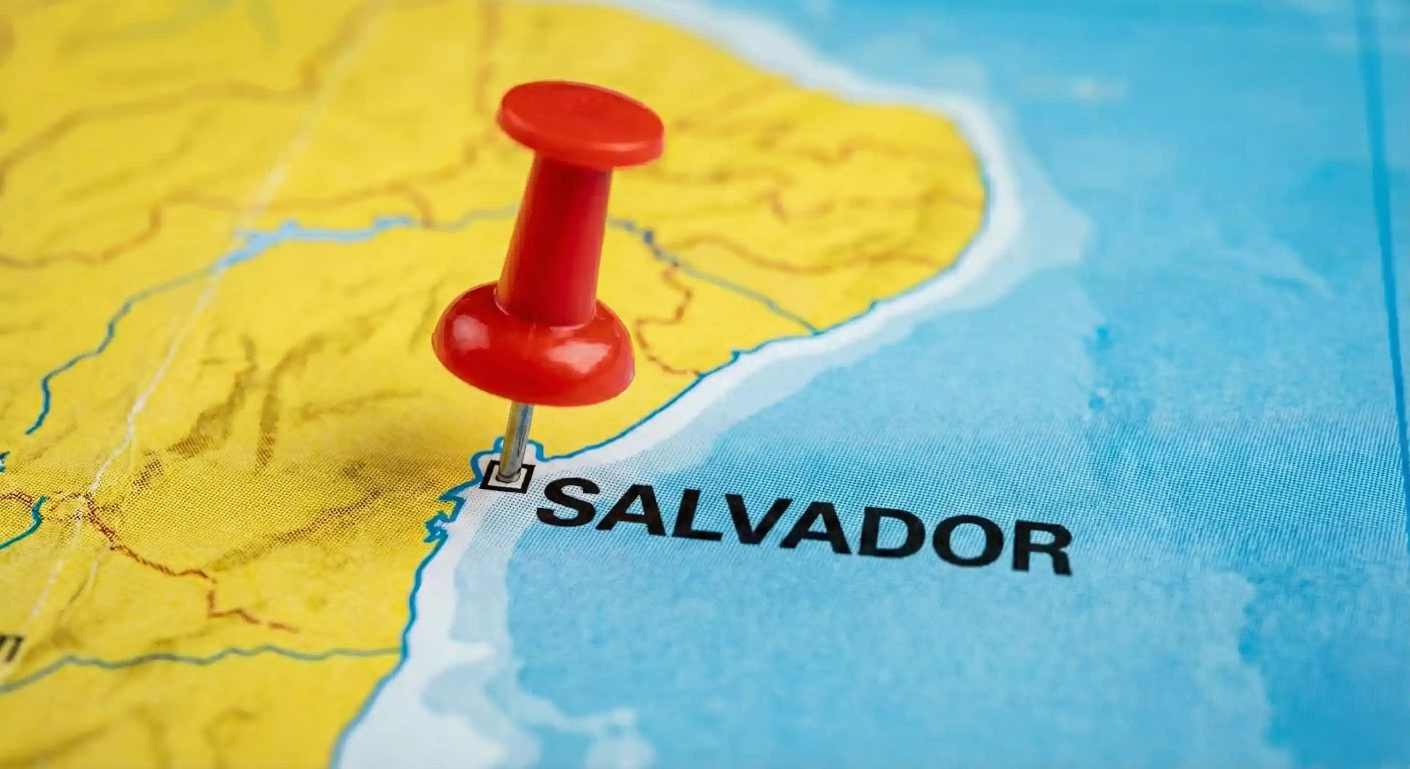 Red pushpin marking the city of Salvador on a coastal map.