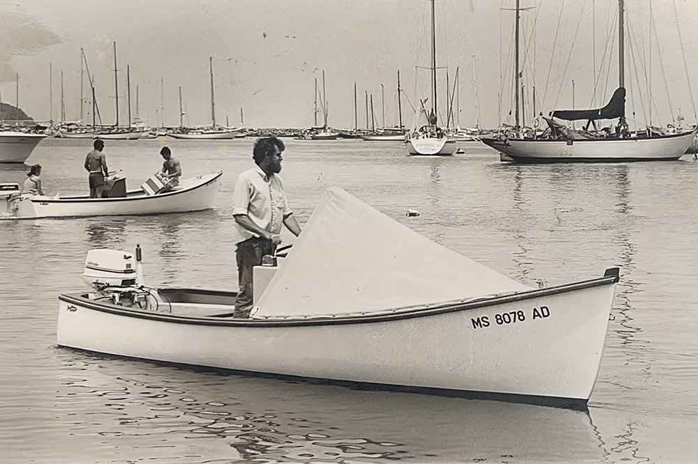 Vintage skiff sailing amongst boats