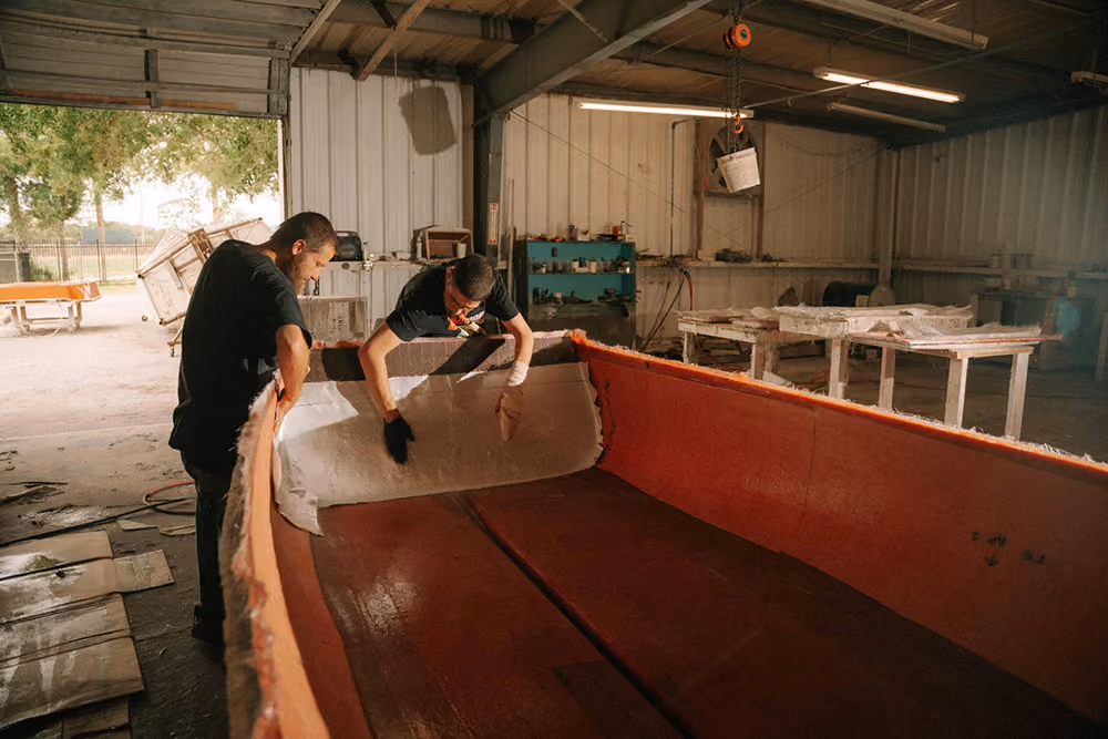 Custom skiff builders working on a hull