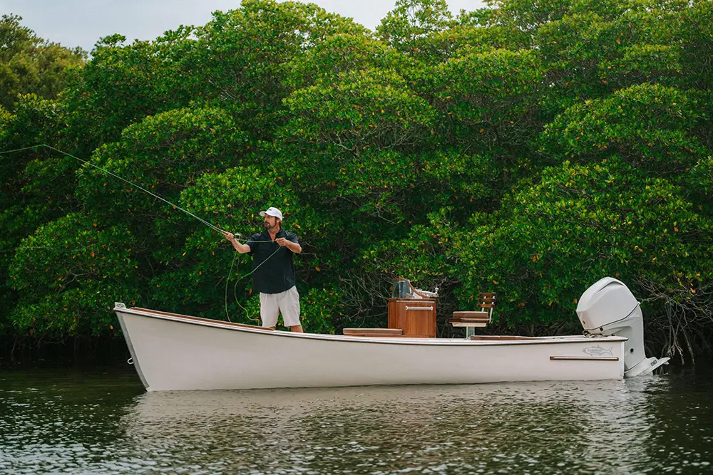 man fly fishing on a custom skiff