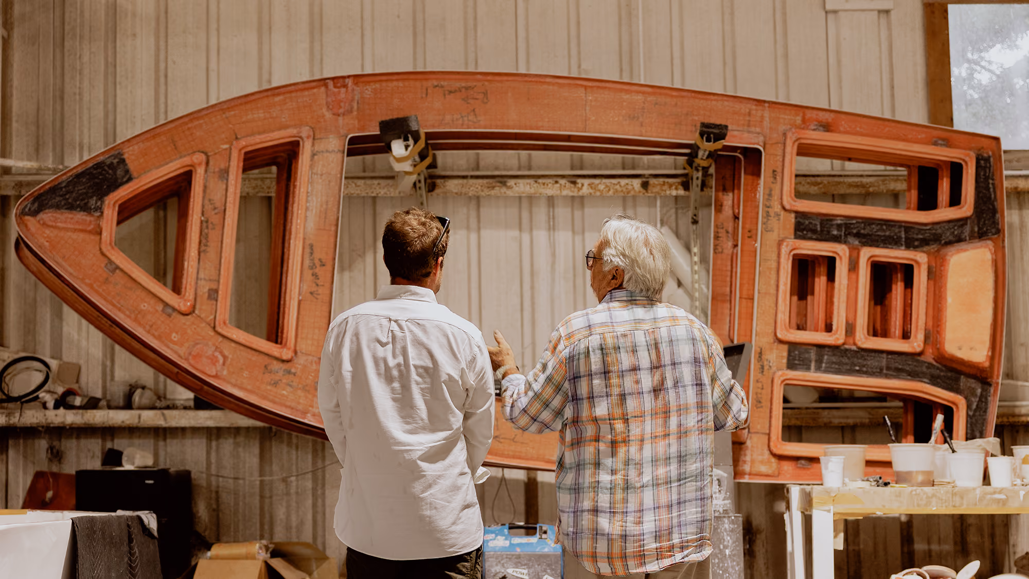 two custom skiff builders looking at the inside of a model