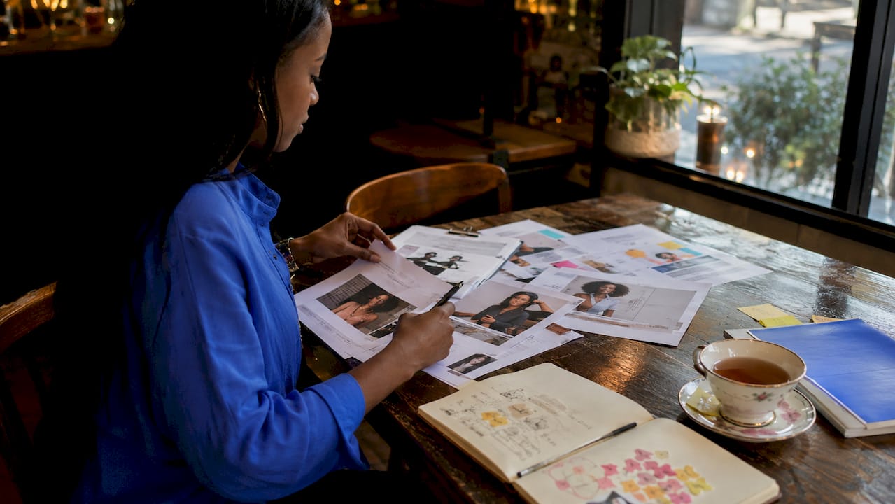 Hands organizing retention strategy documents on desk