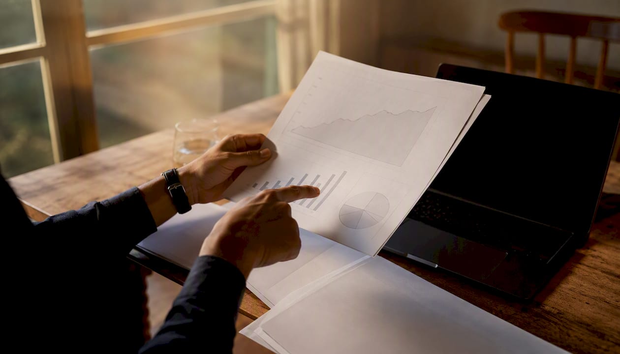 Hands examining marketing mix modeling report