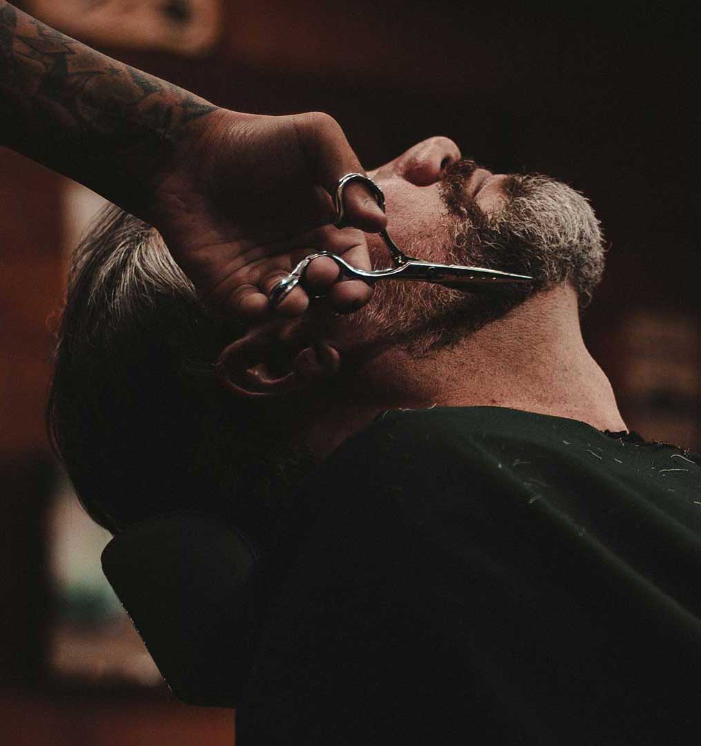 A man having his beard trimmed professionally