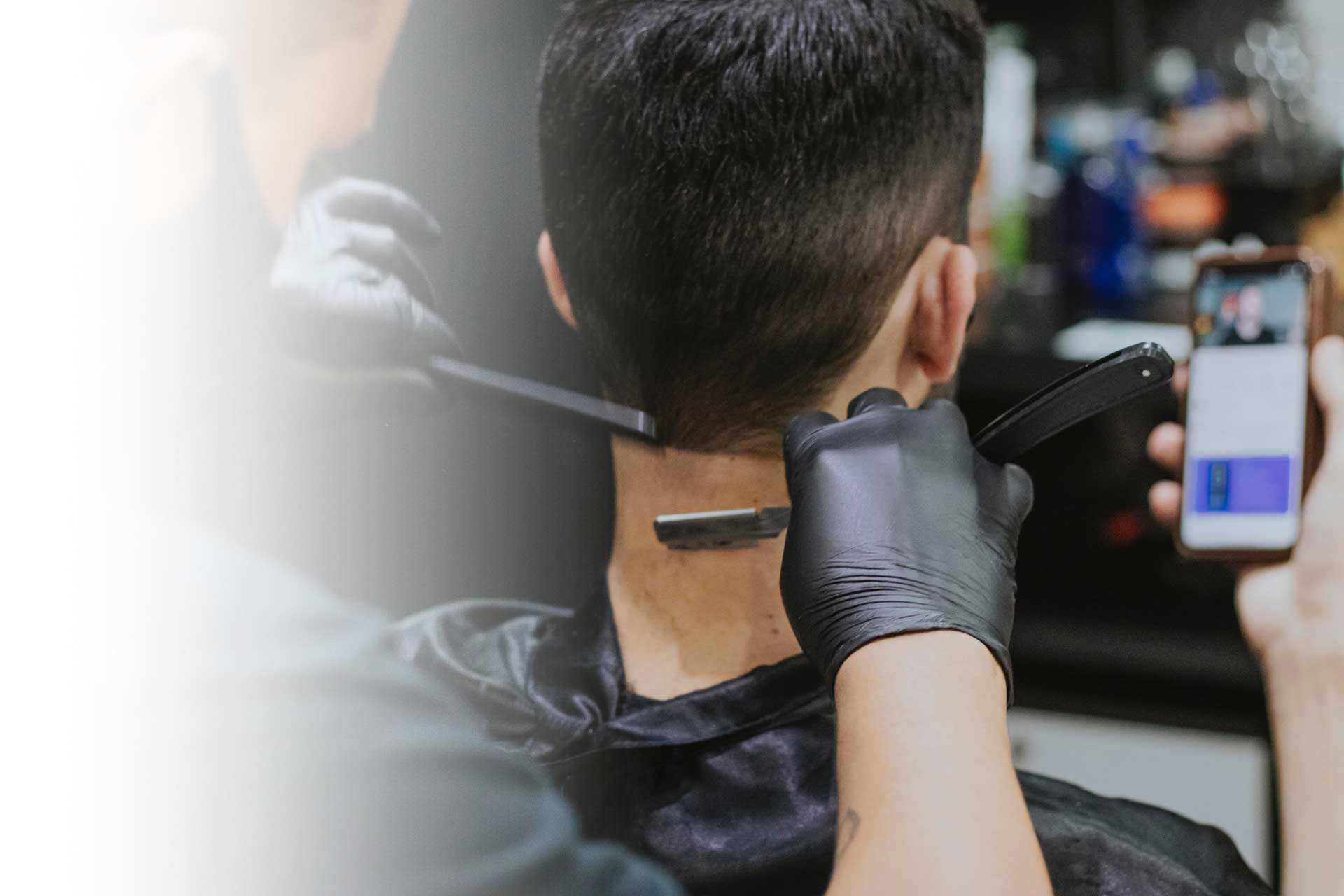 A man getting his head shaved with a razor whilst on the phone to a friend
