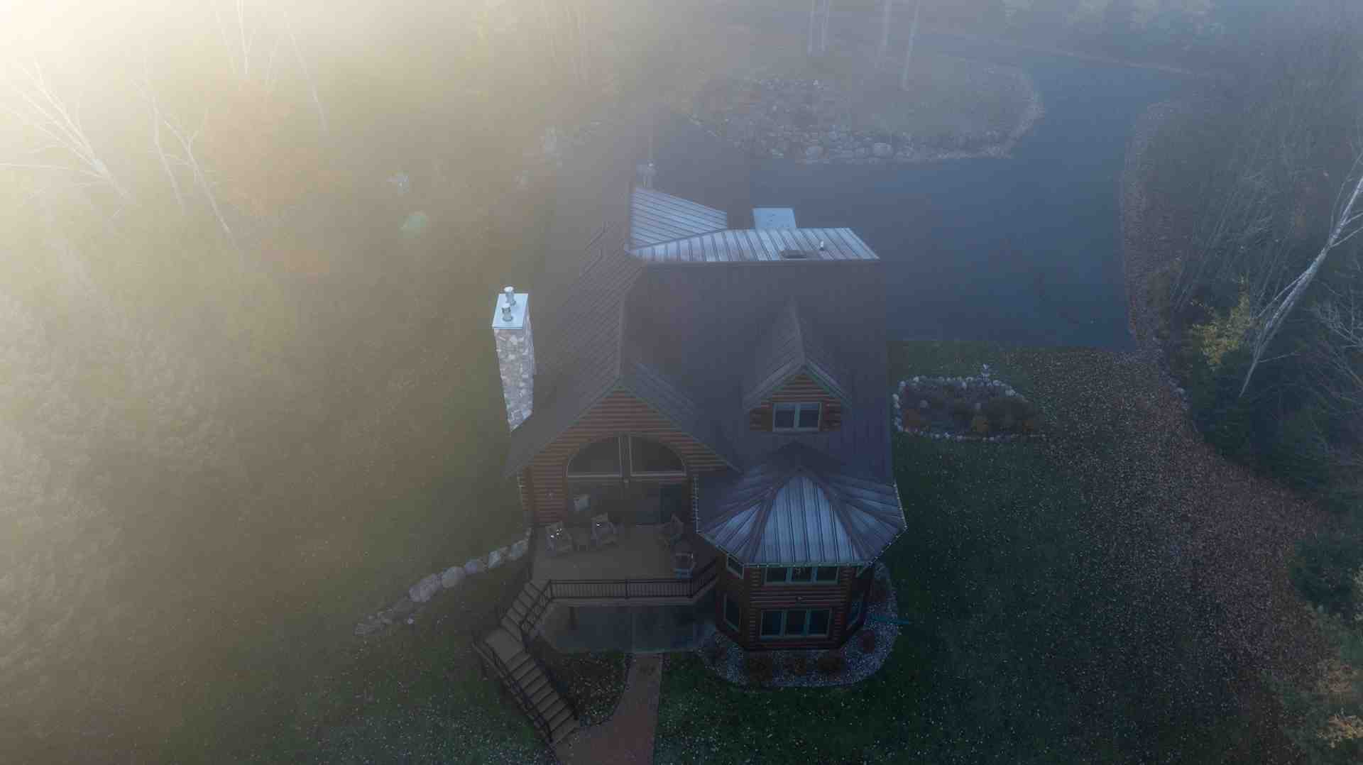 a Northwoods home with a sleek standing seam metal roof surrounded by pine trees - metal roofing wisconsin