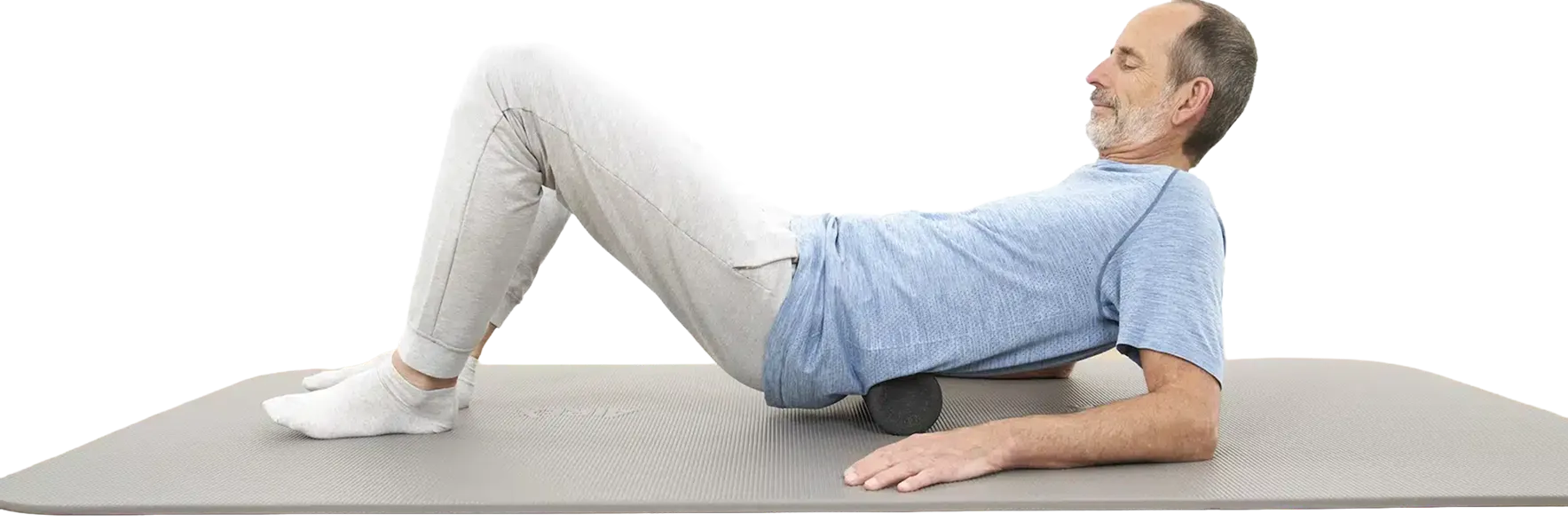 Roland Liebscher & Bracht führt eine Übung mit einer Faszienrolle aus