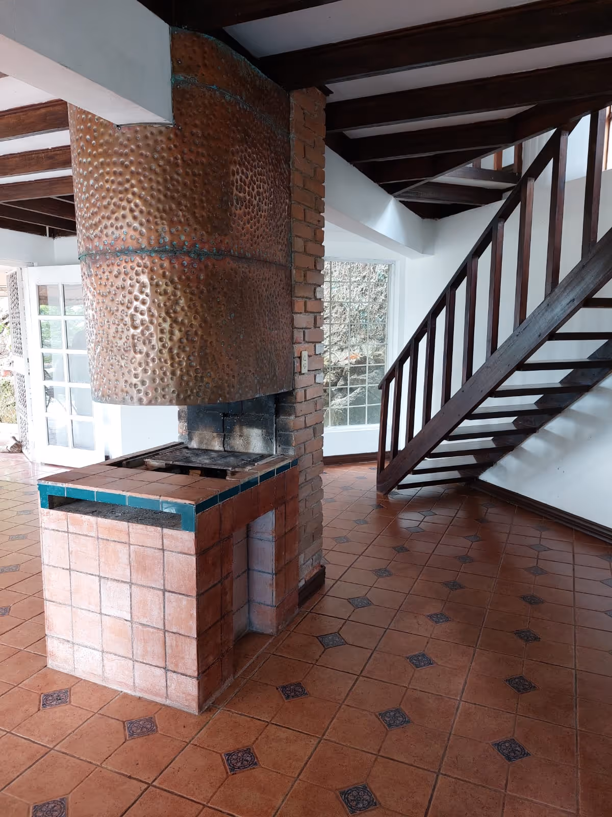 A floor to ceiling copper and brick chimney rises dramatically through the living room — both a conversation piece and a symbol of warmth.