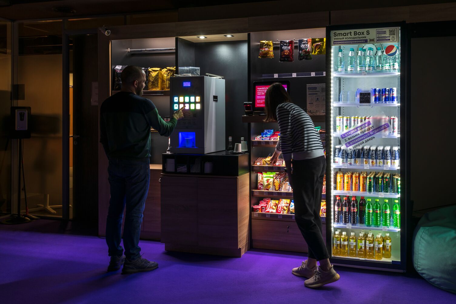 2 people buying snacks from a vending machine