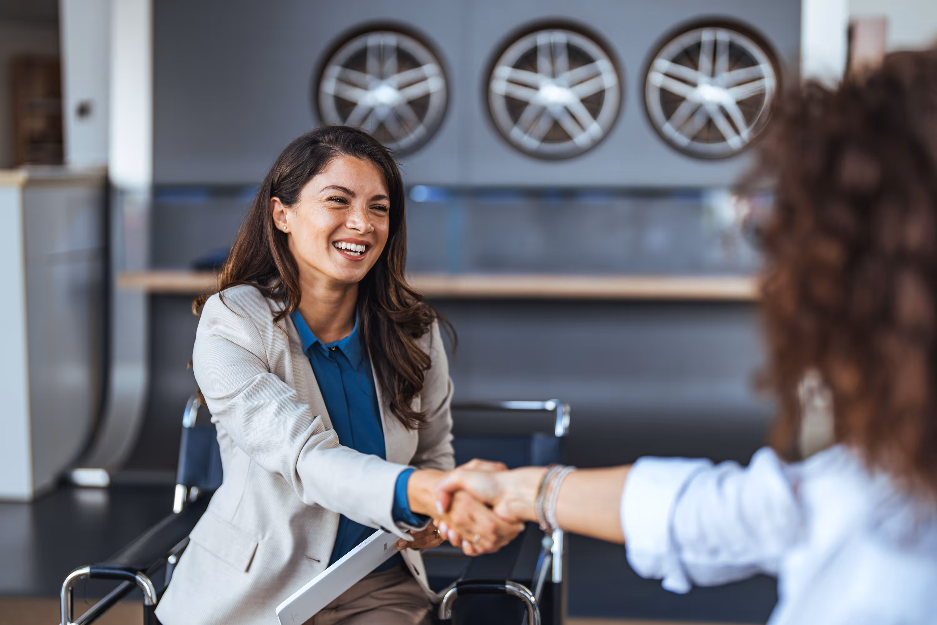 Smiling business woman shaking hands with a faceless person, symbolizing Cydcor trust.