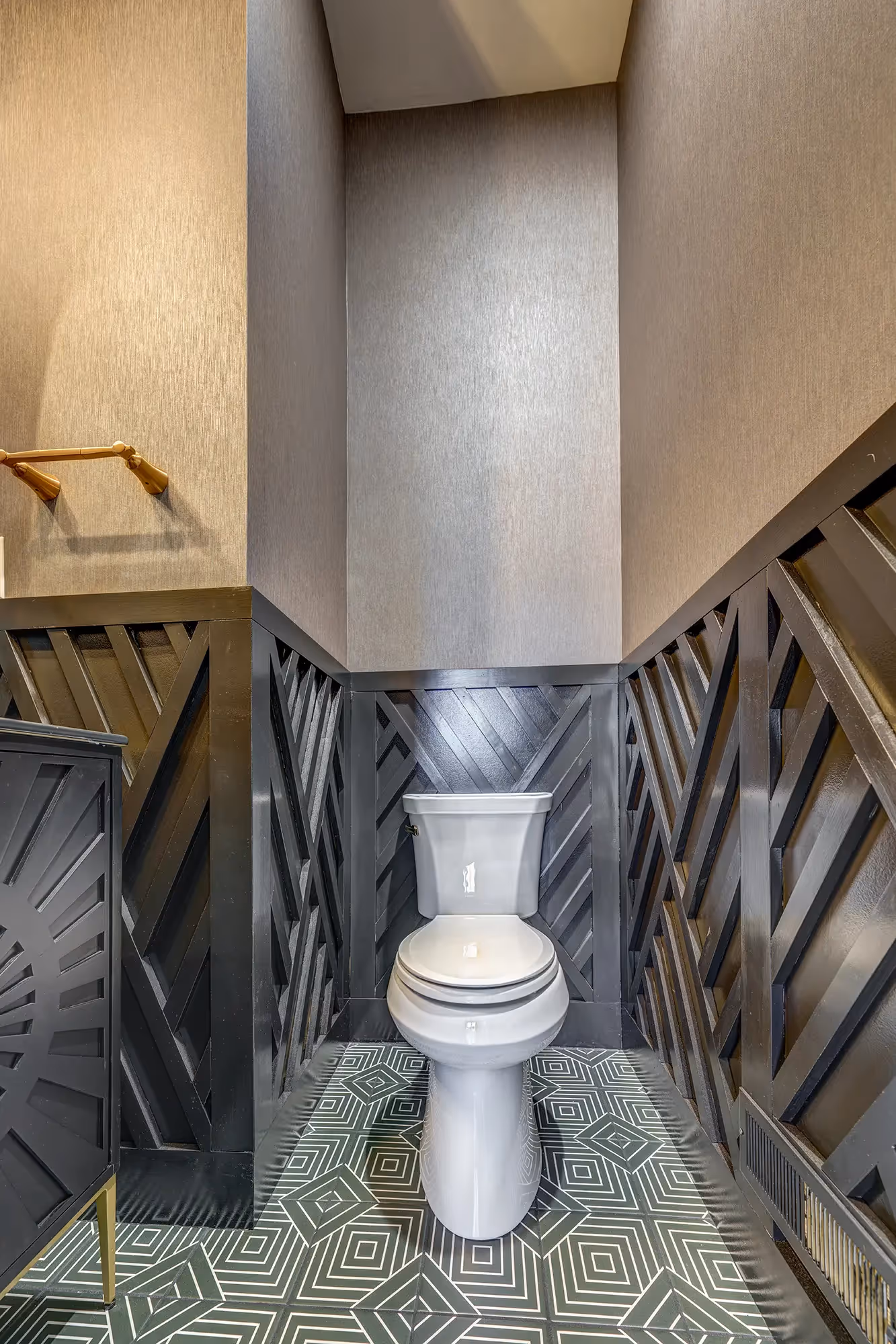 Modern powder room with black herringbone walls, geometric tile flooring, and white toilet in mechanicsburg, pa.