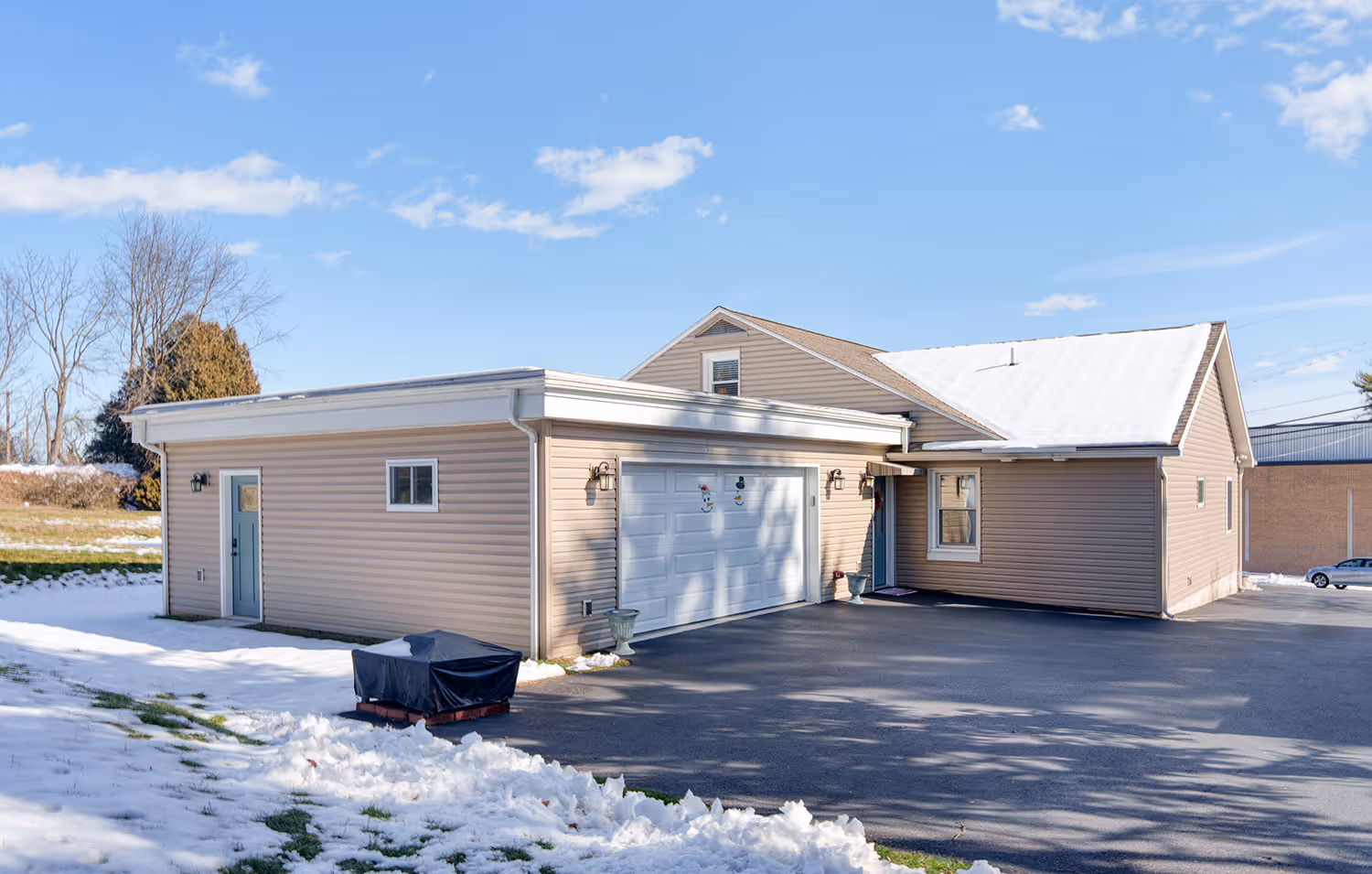 Modern exterior of a home in Lemoyne, PA featuring beige siding and a snow-covered yard.
