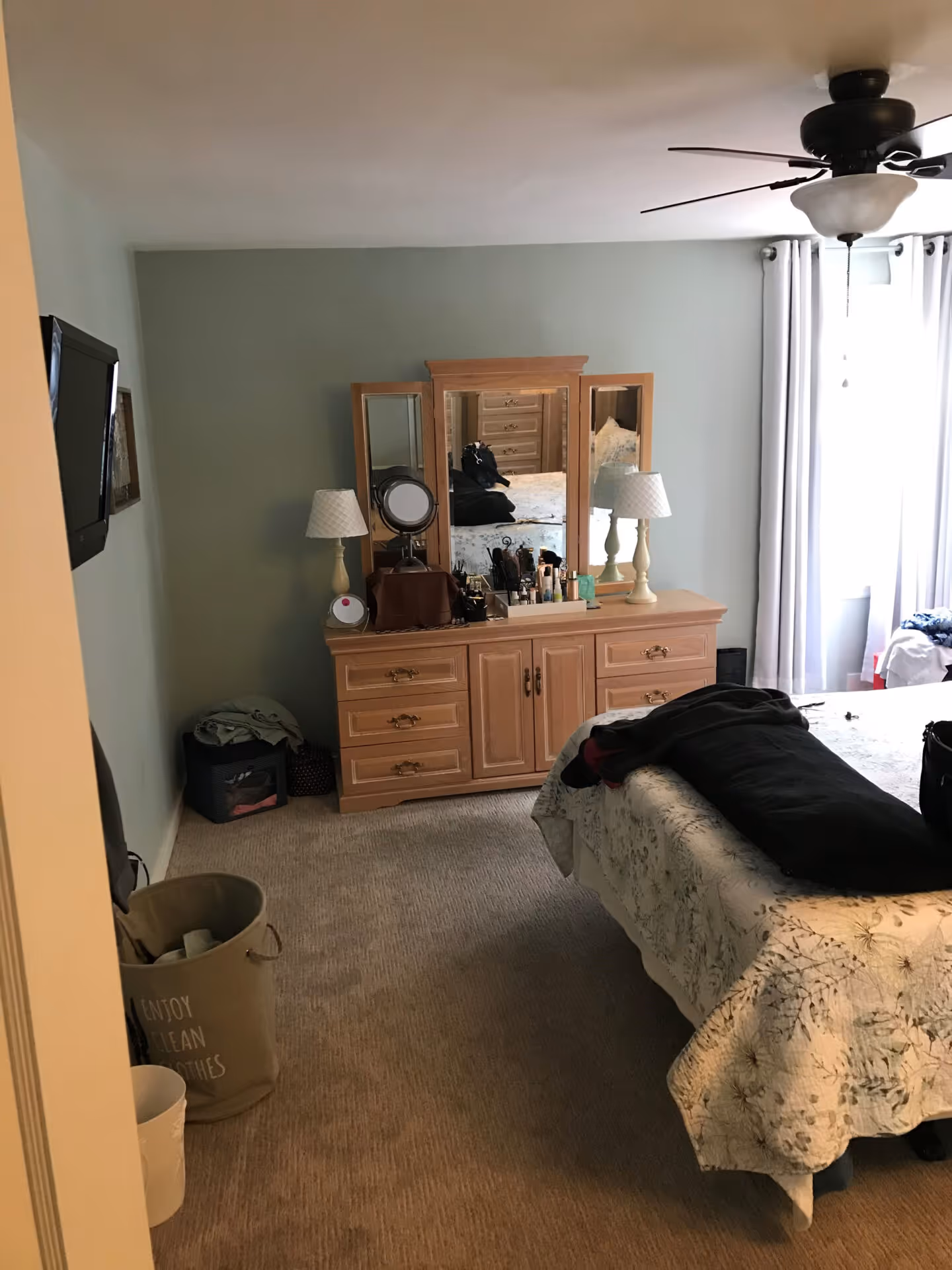 Modern bedroom with light green walls, wooden dresser, and neutral bedding in lemoyne, pa.
