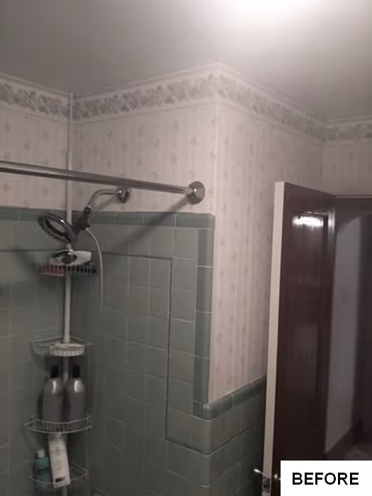 Bathroom with green tiles, floral wallpaper, and shower fixture in New Cumberland, PA