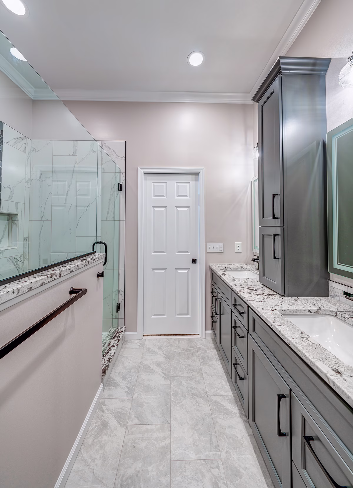 Modern primary bathroom with elegant marble countertops, grey cabinets, and a glass shower in Harrisburg, PA