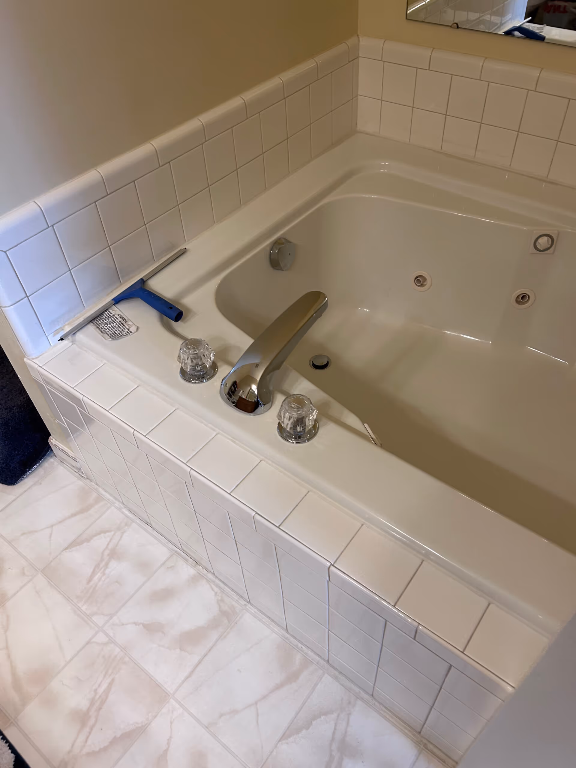 Brown primary bathroom remodeled with a jetted tub, white tile backsplash, and modern fixtures in harrisburg, pa.