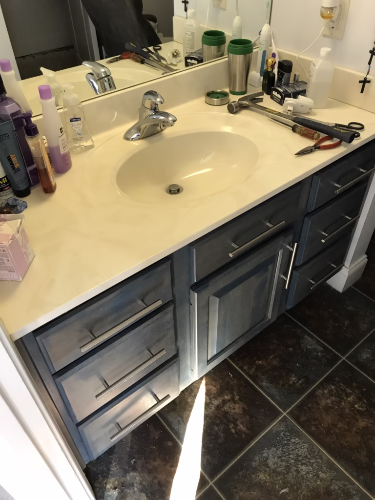 Bathroom remodel featuring a dark blue vanity, marble countertop, and tools in Mechanicsburg, PA