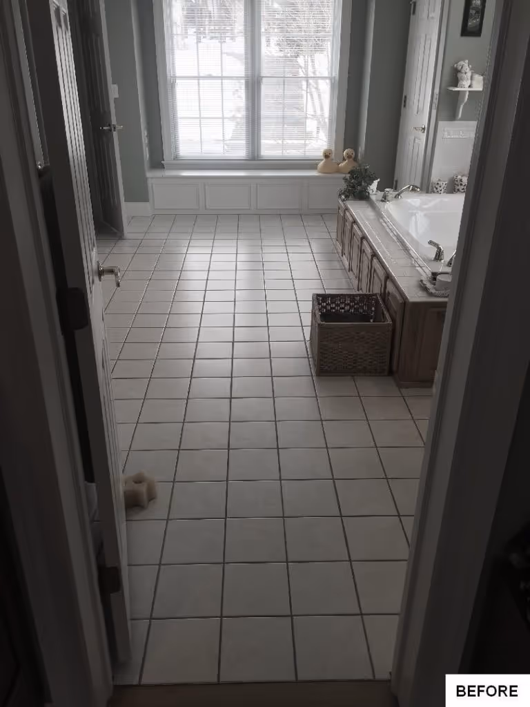 Spacious bathroom with white tiled flooring, a marble bathtub, and natural light in Hummelstown, PA