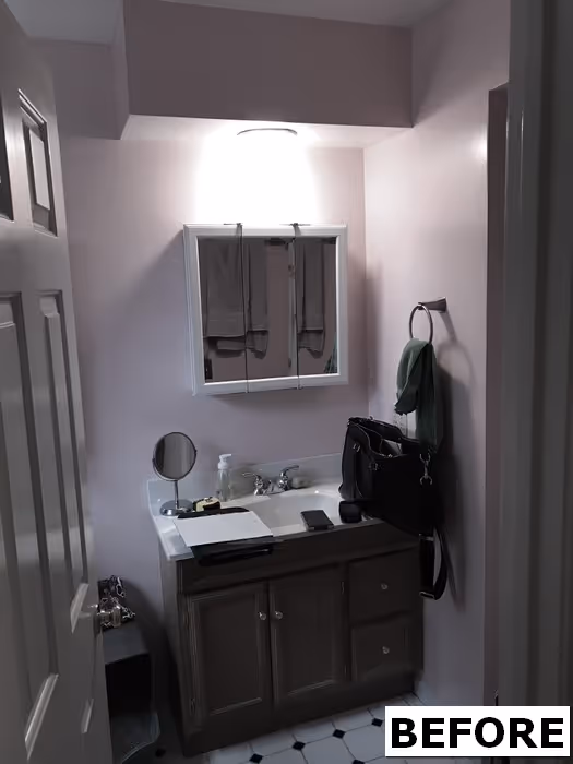 Small bathroom with light pink walls, wooden vanity, and a mirror in Mechanicsburg, PA