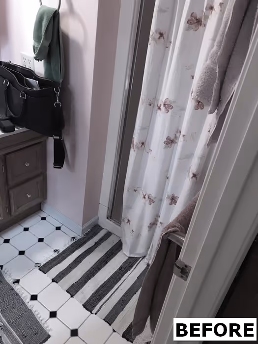 before image of a small bathroom in Mechanicsburg, PA, featuring pink walls, white tile flooring, and floral shower curtain