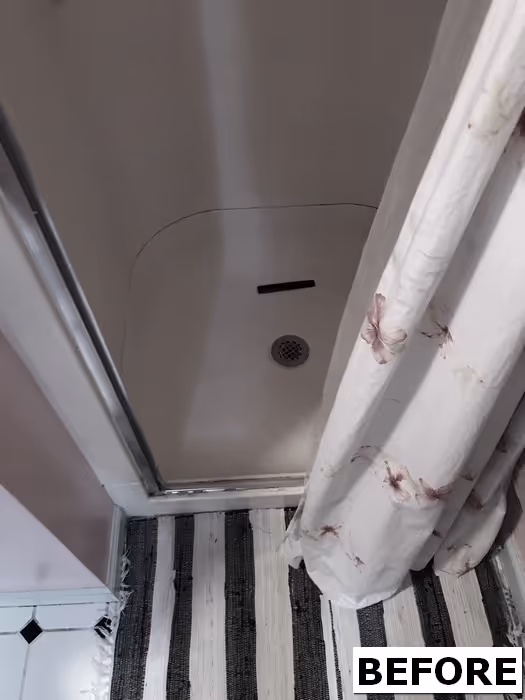 Renovation-ready shower space with floral curtain and striped rug in mechanicsburg, pa