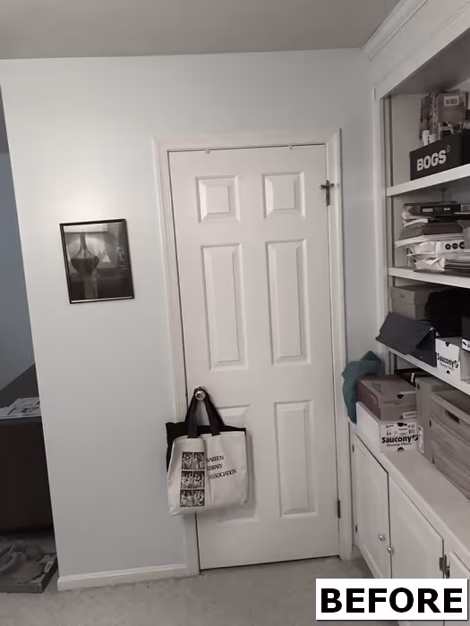 Before image of a small room featuring a white door, shelves with boxes, and a light blue wall in mechanicsburg, pa.