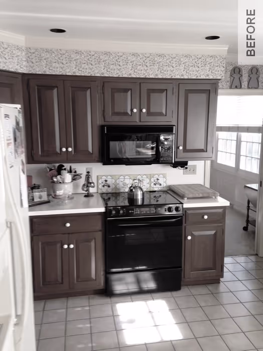 Cozy transitional kitchen with dark wood cabinets, black appliances, and colorful backsplash in Camp Hill, PA.