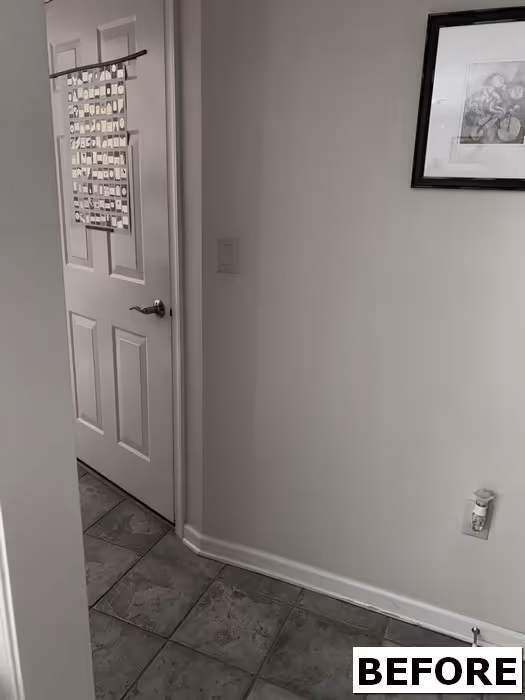 Entryway with a closed door and decorative artwork, featuring light gray walls and tiled flooring in floribunda heights, camp hill, pa.