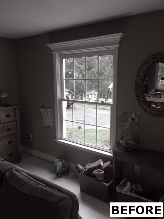 Cozy living room with a window exposing light, featuring a wooden dresser and decorative elements, New Cumberland, PA