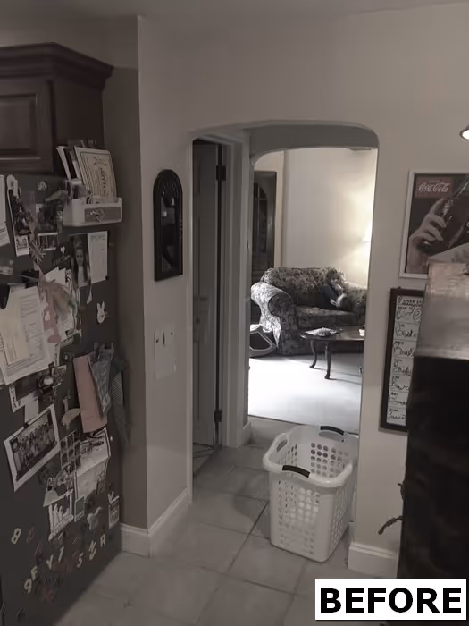 Kitchen area leading to a living room, featuring a patterned couch and laundry basket in new cumberland, pa