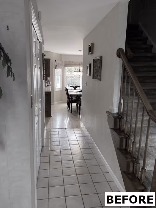 Transitional hallway in Mechanicsburg, PA featuring tile flooring and staircase leading to an upper level.