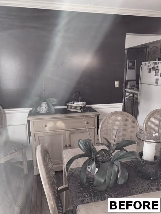 Modern dining room in Mechanicsburg, PA featuring a dark wall and wooden furniture with plants.