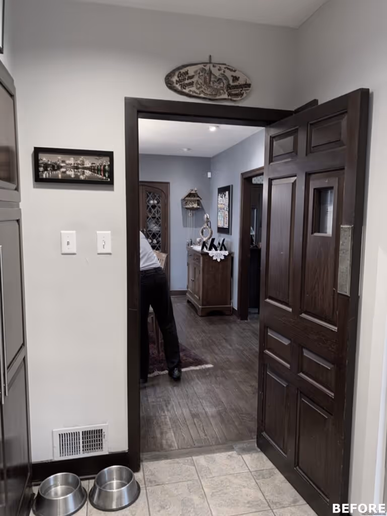 Traditional entryway with dark wooden door and flooring, featuring pet bowls and gray walls in Harrisburg, PA.