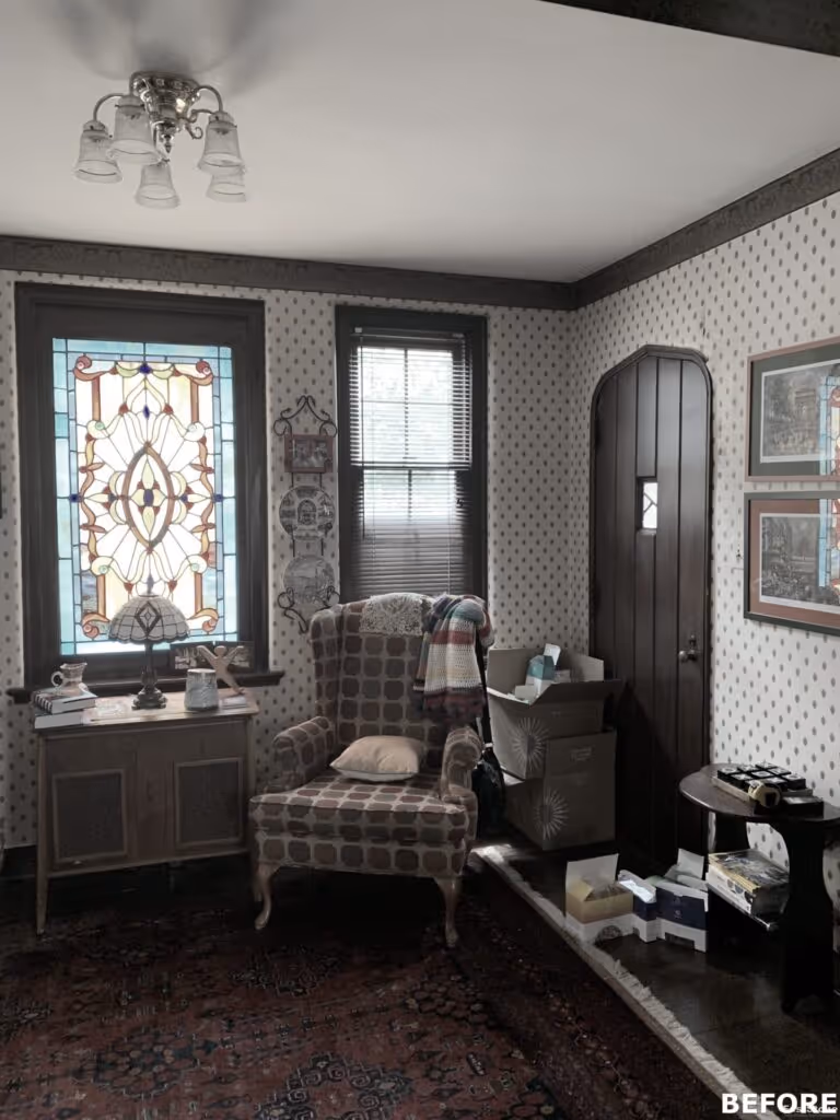 Cozy living room with stained glass window, vintage armchair, and patterned walls in Harrisburg, PA.
