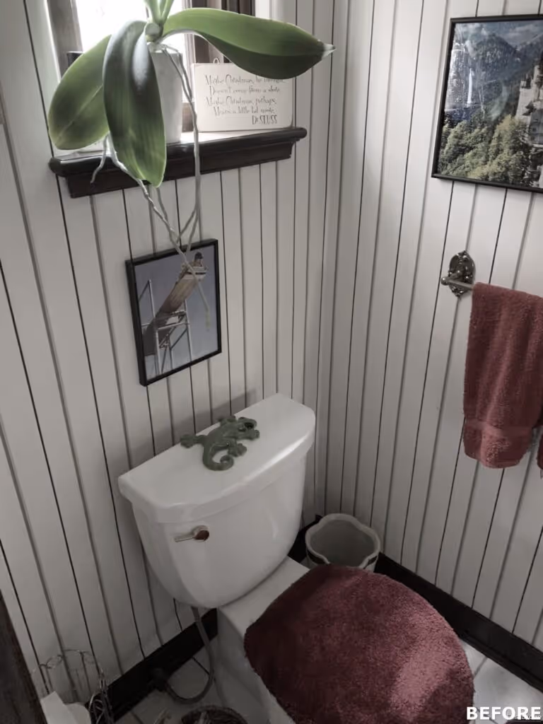 Cozy bathroom with a white toilet and red accents, featuring vertical wooden paneling and decorative plants in harrisburg, pa