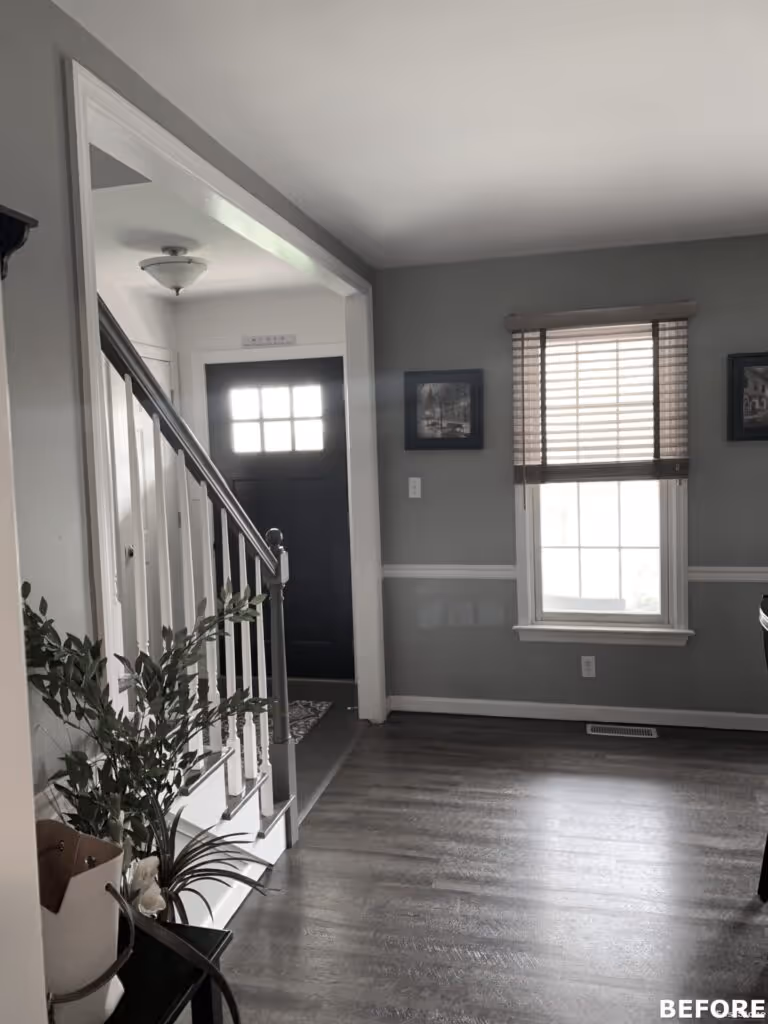 Welcoming foyer with a staircase, dark front door, and decorative wall art in Hummelstown, PA