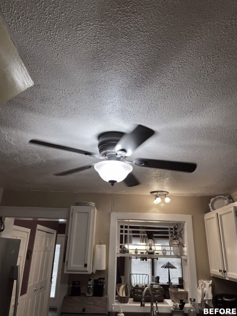 Bright kitchen with ceiling fan and light fixtures in Camp Hill, PA, featuring cabinets and a window view.