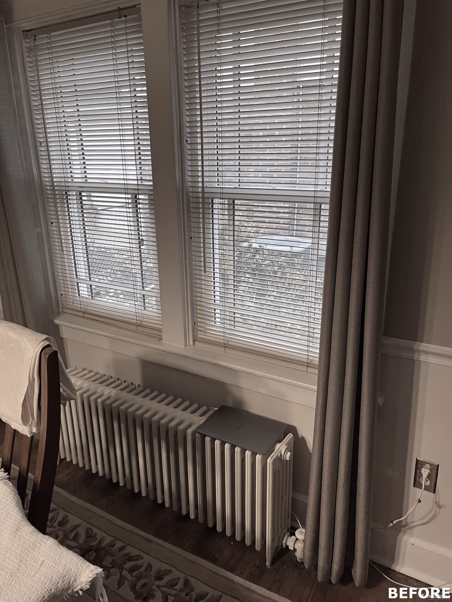Cozy living room with large windows, white radiator, and beige curtains in Camp Hill, PA