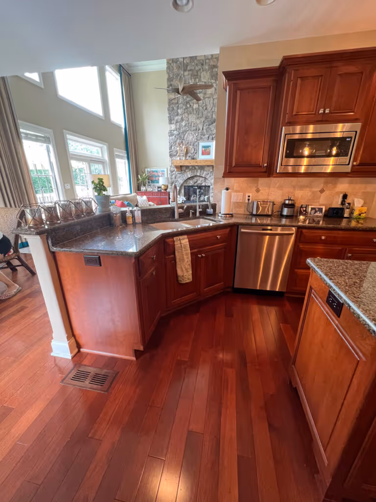 Luxurious kitchen with rich wood cabinets, granite countertops, and a stone accent wall in Mechanicsburg, PA