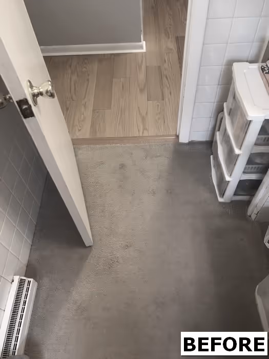 A bathroom entryway with a grey carpet, tiled walls, and light wood flooring, located in Harrisburg, PA.