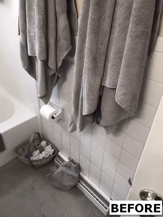 Minimalist bathroom in Harrisburg, PA, featuring gray towels and modern elements.
