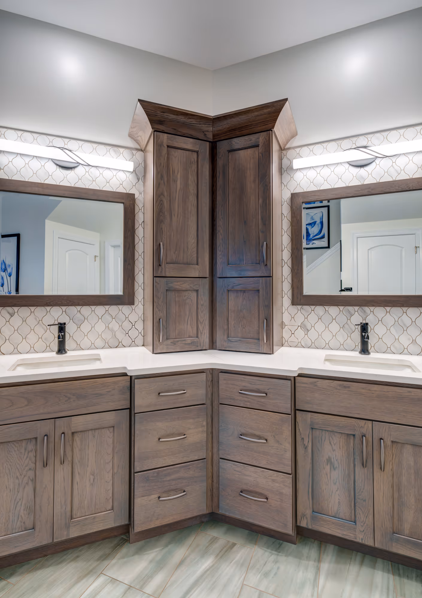 Luxury bathroom in Mechanicsburg, PA featuring dark wooden cabinets, a marble countertop, and an intricate tile backsplash.