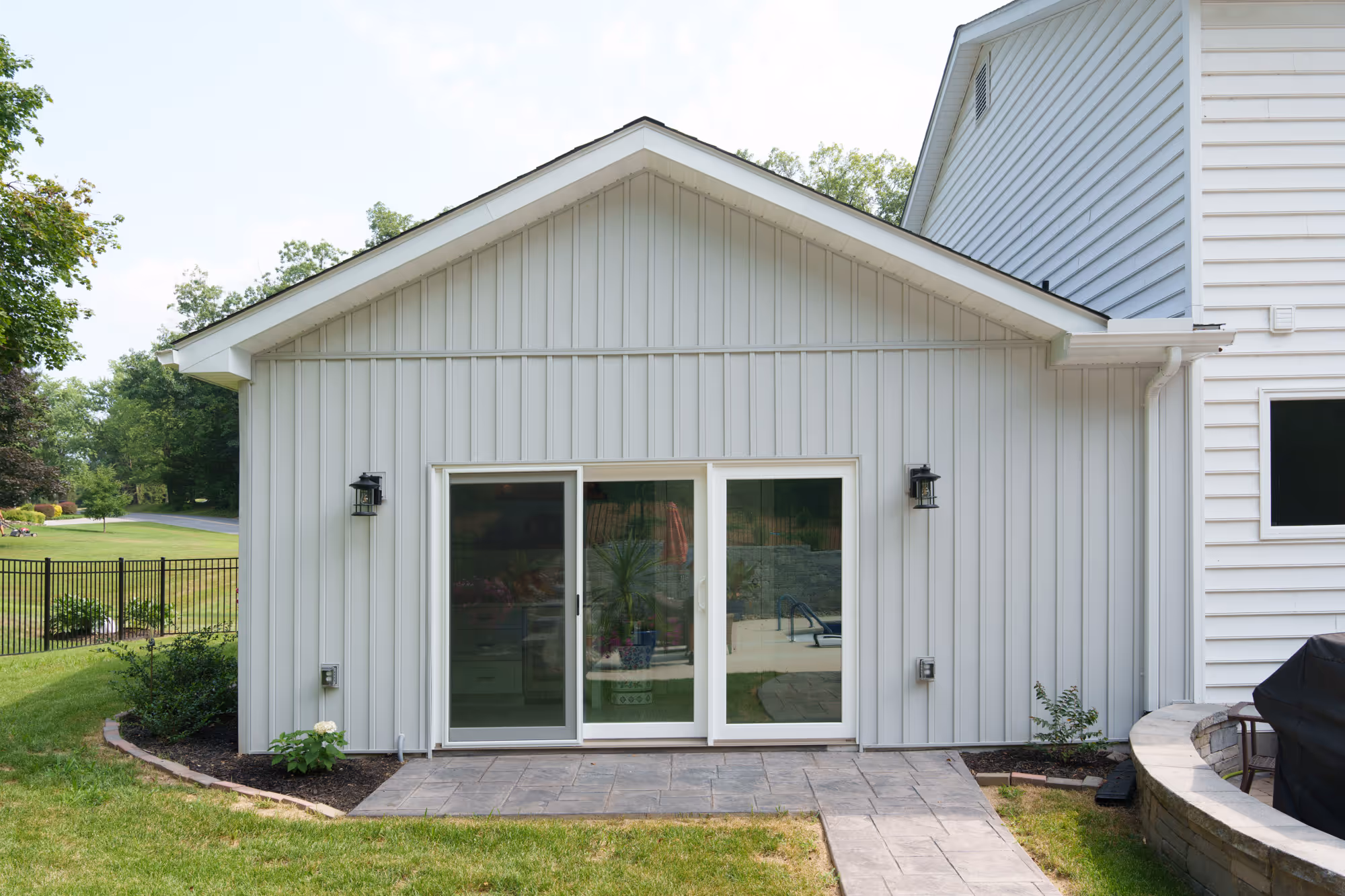 Exterior view of a contemporary home addition with gray vertical siding entryway, located in gettysburg, pa.