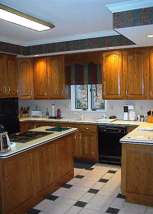 Warm wood kitchen featuring a cozy design with black appliances and decorative wallpaper in Harrisburg, PA