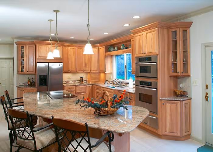 Warm wood cabinetry kitchen with granite countertops and modern appliances in Harrisburg, PA
