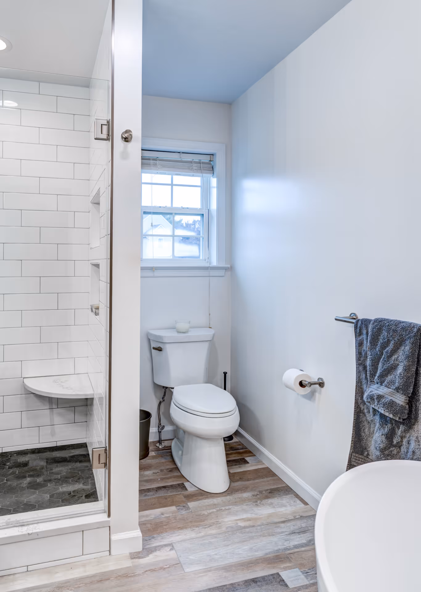 Modern bathroom with a walk-in shower, white subway tiles, and wood-look flooring in Elizabethtown, PA.