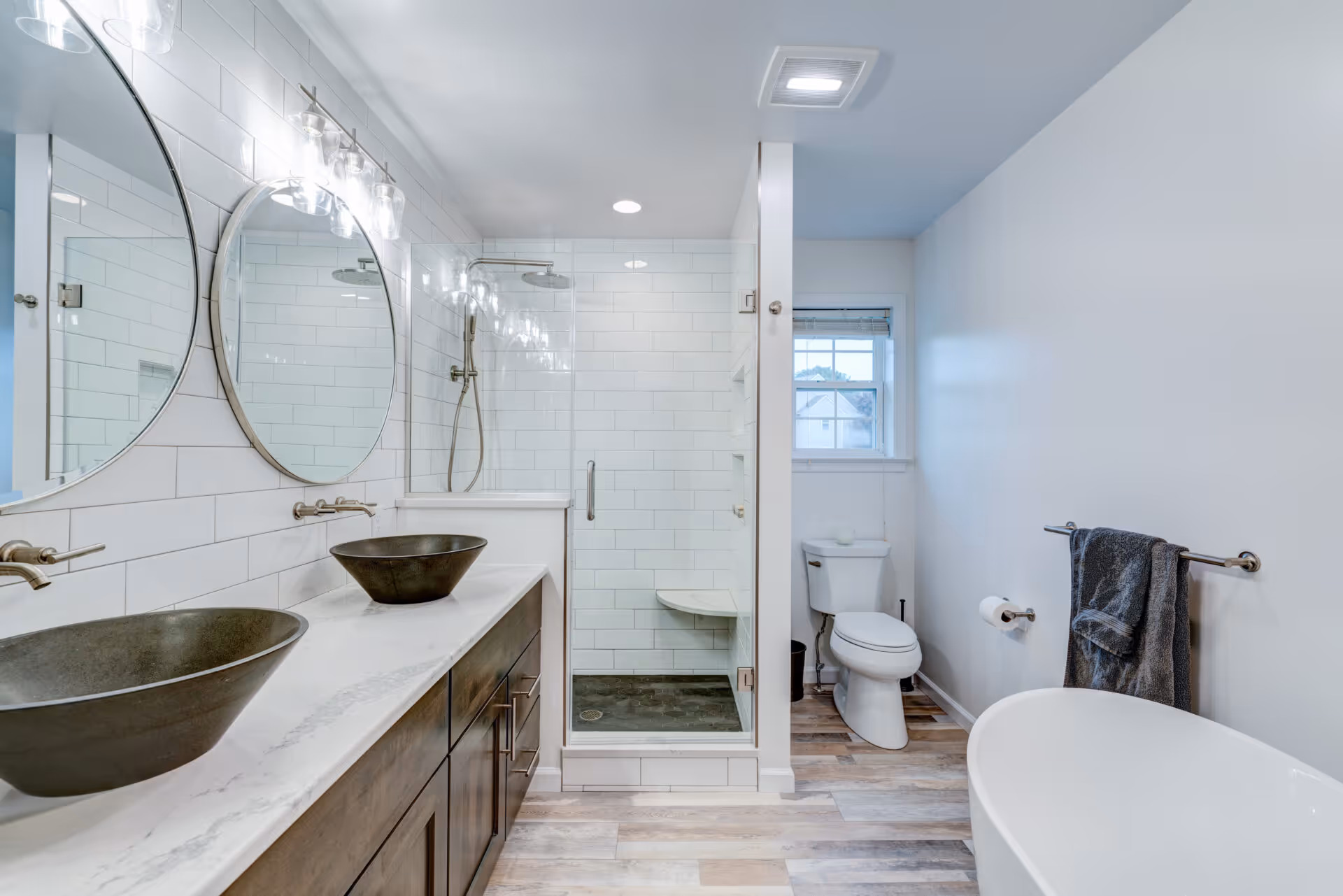 Modern bathroom with dual vessel sinks, glass shower, and freestanding tub in Elizabethtown, PA.