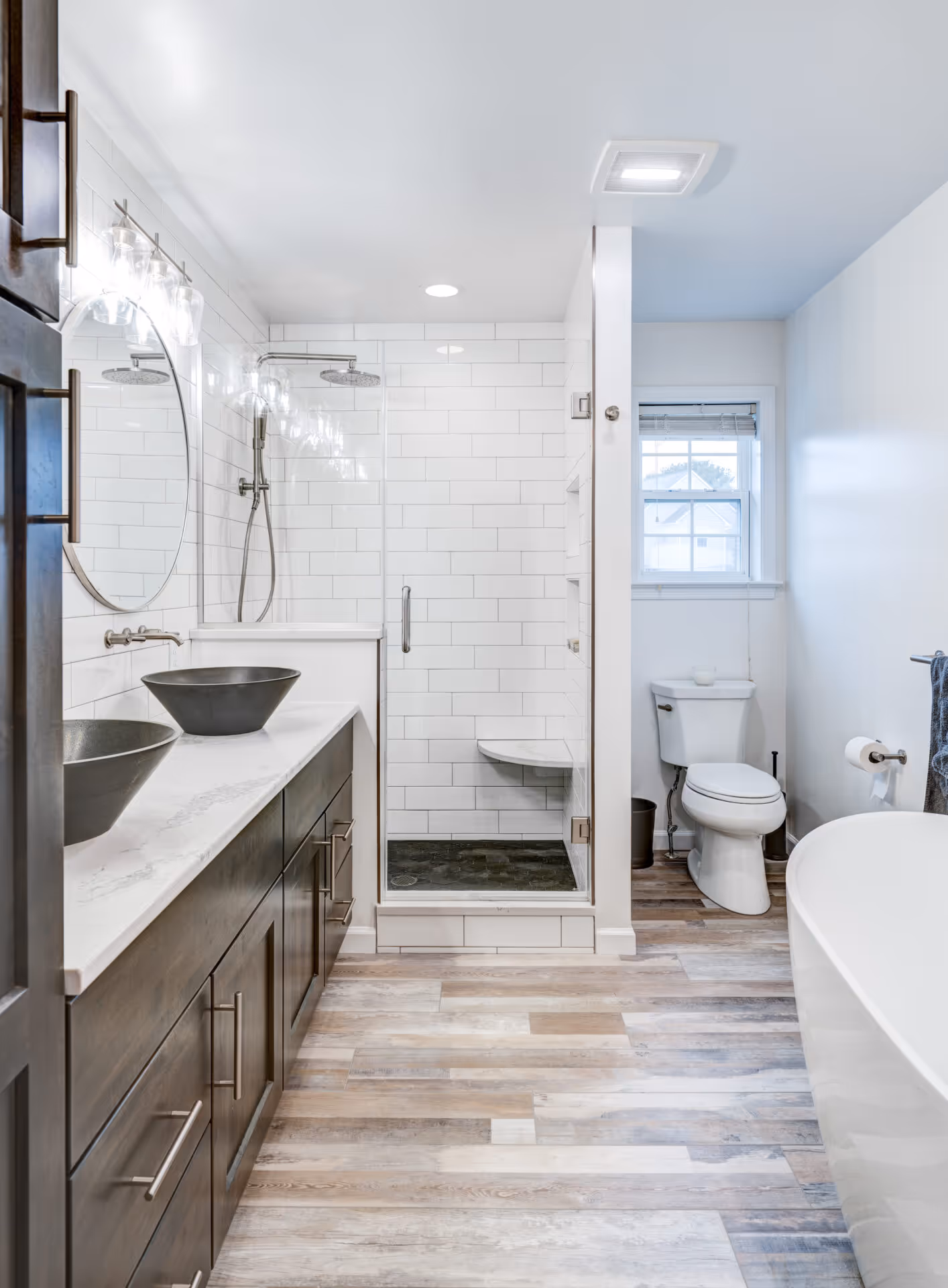 Modern bathroom in Elizabethtown, PA featuring dual vessel sinks, subway tile shower, and freestanding tub.