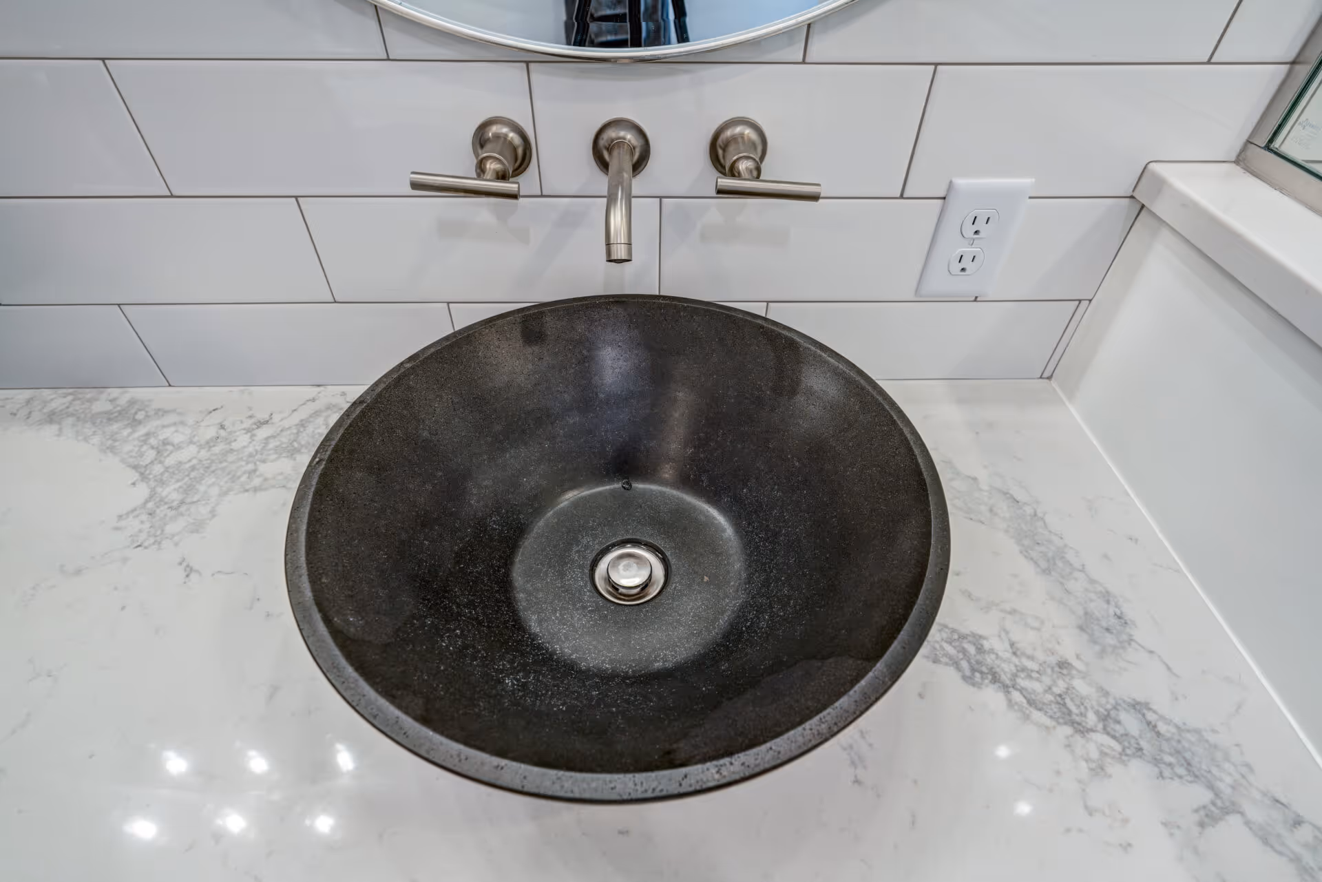 Luxurious bathroom with a modern round black vessel sink and marble countertop in Elizabethtown, PA.