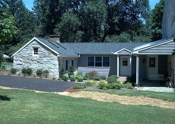 Modern farmhouse exterior featuring stone accents and green landscaping in boiling springs, pa